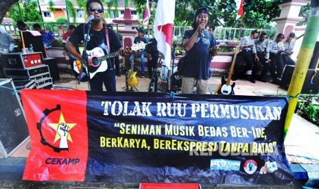 Musisi menyanyikan sejumlah lagu dari Iwan Fals ketika berunjuk rasa menolak RUU tentang Permusikan di depan kantor DPRD Pamekasan, Jawa Timur, Senin (18/2/2019). 