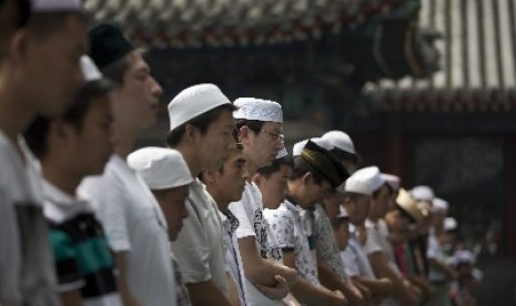 Muslim Cina dari kalangan etnis Hui tengah melaksanakan shalat. Muslim di Cina barat daya itu mencoba menghentikan upaya penghancuran atap kubah masjid berusia berabad-abad