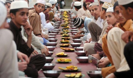 Muslim di Pakistan menunggu saat berbuka puasa bersama di sebuah masjid di Peshawar.