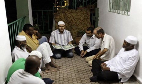  Muslim Kuba mendengarkan pembacaan ayat suci Alquran usai makan Iftar atau buka puasa bersama di Havana, Cuba, Jumat (3/8).   (Desmond Boylan/Reuters)