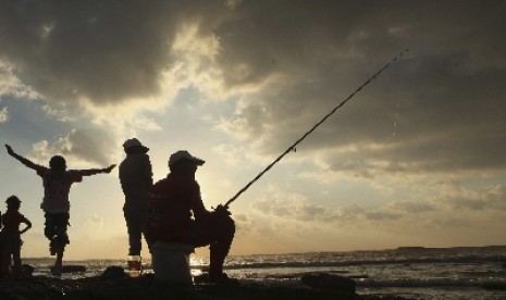 Muslim Libya menikmati senja dengan memancing di pelabuhan di Kota Benghazi.