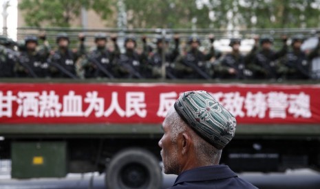 Muslim Uighur di depan aparat Cina