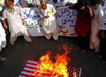 Muslim di Pakistan membakar bendera AS dan meneriakkan slogan anti-Amerika dalam demonstrasi anti Facebook, 21 Mei 2010.