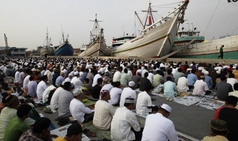 Muslims attend mass prayers marking the Muslim sacrifice day of Eid al-Adha at Sunda Kelapa port in Jakarta October 26, 2012.  