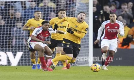 Myles Lewis-Skelly dari Arsenal melanggar Matt Doherty dari Wolverhampton Wanderers yang menyebabkan kartu merah selama pertandingan sepak bola Liga Primer Inggris di Stadion Molineux, Wolverhampton, Inggris, Sabtu 25 Januari 2025.