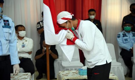 Narapidana tindak pidana teorisme mencium bendera Merah Putih usai mengucap ikrar setia kepada Negara Kesatuan Republik Indonesia (NKRI) di Aula Sahardjo, Lapas Narkotika Kelas IIA Gunung Sindur, Kabupaten Bogor, Jawa Barat, Kamis (15/4/2021). Sebanyak 34 narapidana tindak pidana terorisme mengikuti ikrar setia kepada NKRI sebagai bentuk implementasi hasil akhir program deradikalisasi serta pengikat tekad dan semangat untuk menegaskan bersedia kembali membangun kehidupan berbangsa dan bernegara dalam bingkai NKRI.