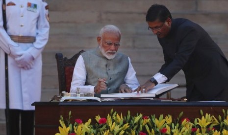 Narendra Modi, menandatangani berkas usai mengucapkan sumpah jabatan untuk kedua kalinya sebagai perdana menteri di New Delhi, Kamis (30/5). 