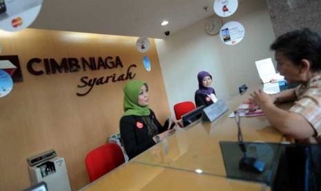 Nasabah melakukan transaksi di kantor layanan CIMB Niaga Syariah, Jakarta.