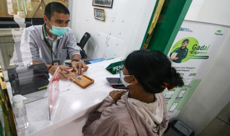 Nasabah melakukan transaksi di kantor gadai. Otoritas Jasa Keuangan (OJK) memberikan izin usaha bagi dua perusahaan pegadaian