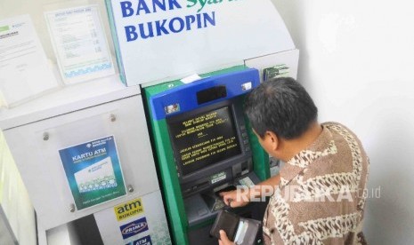 Nasabah melakukan transaksi meggunakan mesin ATM Bank Syariah Bukopin di Jakarta, Ahad (2/10). 