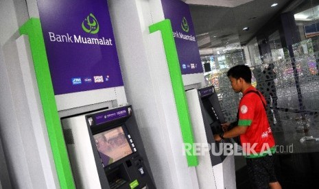 Nasabah melakukan transaksi menggunakan mesin ATM Bank Muamalat di Jakarta.