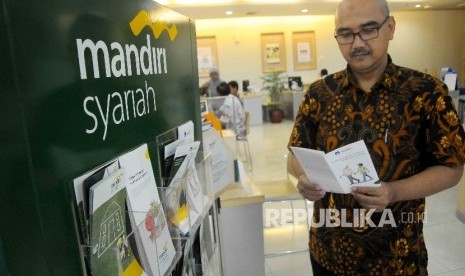 Nasabah membaca katalog fasilitas Bank Syariah Mandiri (BSM) di Banking Hall BSM, Jakarta, Jumat (13/1)