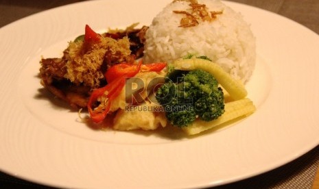 Makanan nasi dengan ayam goreng dan lauk sayur disukai sebagai menu makan di Indonesia.