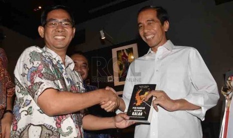   Pemimpin Redaksi Harian Republika, Nasihin Masha memberikan buku 'Perjuangan Melawan Kalah' kepada Presiden terpilih, Joko Widodo saat peluncuran buku tersebut di Jakarta, Selasa (2/9). (Republika/Agung Supriyanto)