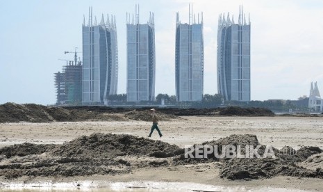   Nelayan berjalan di area proyek reklamasi pulau G, Jakarta, Ahad (17/4).  (Republika/Yasin Habibi)