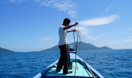 Nelayan bernama Idris (42) di atas perahunya di perairan Kepulauan Natuna.