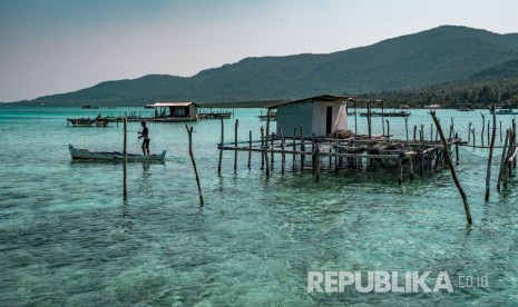 Nelayan melintas di sekitar karamba ikan kerapu di tepi Pantai Lego, Karimunjawa, Jepara, Jawa Tengah, Jumat (27/7). 