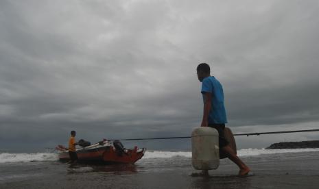 Nelayan memindahkan bahan bakar untuk kapal bagan saat langit berawan di Pantai Pasie Nan Tigo, Padang, Sumatera Barat, Senin (2/11/2020). BMKG merilis peringatan dini cuaca ekstrem di 25 wilayah Indonesia pada Senin (2/11/2020), dengan rincian 23 daerah berpotensi hujan lebat yang dapat disertai kilat atau petir dan angin kencang di antaranya Aceh, Sumatera Utara, Sumatera Barat, Riau, Bengkulu, dan Jambi.