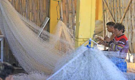 Nelayan memperbaiki jaring sebelum melaut di muara Karangsong, Indramayu, Jawa Barat, Kamis (15/9/2022). Pemprov Jawa Barat menyiapkan anggaran subsidi sebesar Rp27 miliar bagi nelayan, petani dan pelaku umkm yang terdampak kenaikan harga BBM. 