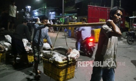 Nelayan mengangkat ikan-ikan beku, yang berasal dari pelabuhan Muara Baru di kampung nelayan Kalibaru Cilincing, Jakarta, Utara, Sabtu (4/3) malam. 