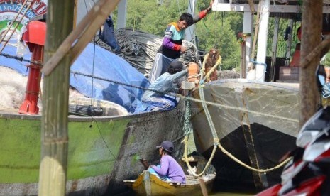  Nelayan mengecat kapal di dermaga Pantai Karangsong, Kabupaten Indramayu, Kamis (20/2). (Republika/Edi Yusuf)