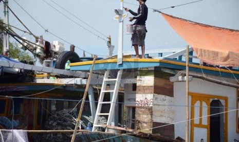  Nelayan mengecat kapal di dermaga Pantai Karangsong, Kabupaten Indramayu, Kamis (20/2). (Republika/Edi Yusuf)