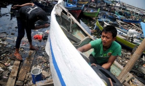 Nelayan mengecat perahu di Permukiman Nelayan Cilncing, Jakarta, Rabu (11/6). 