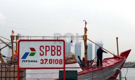 Nelayan mengisi solar di atas kapal di Stasiun Pengisian Bahan Bakar di Muara Baru, Jakarta, Rabu (26/2).