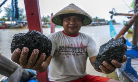 Nelayan menunjukkan bongkahan batu bara yang tersangkut jaring ikan usai melaut di Roban Timur, Subah, Kabupaten Batang, Jawa Tengah, Selasa (22/12/2020). Sejumlah nelayan setempat mengeluh jaring penangkap ikannya rusak dan merugi hingga 50 persen akibat tersangkut batu bara yang berasal dari kapal pengangkut batu bara di sekitaran perairan laut yang berdekatan dengan PLTU Batang.