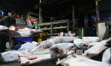 Nelayan menurunkan ikan-ikan beku dari atas mobil pick up, yang berasal dari pelabuhan Muara Baru di kampung nelayan Kalibaru Cilincing, Jakarta, Utara, Sabtu (4/3) malam.