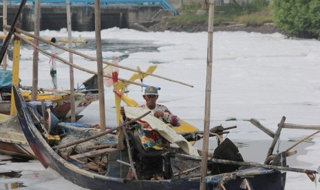 Nelayan menutup mesin perahu di sekitar muara Sungai Tambak Wedi yang dipenuhi limbah busa putih di Surabaya, Jawa Timur, Senin (21/3).