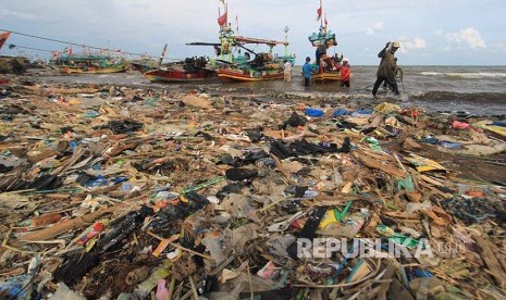 [ilustrasi] Nelayan menyandarkan perahunya di bibir pantai yang dipenuhi sampah plastik di Desa Dadap, Indramayu, Jawa Barat.