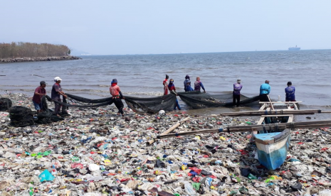 Nelayan payang usai menebar jaring di tengah laut lalu ditarik talinya dari darat beramai-ramai ke pantai, terganggu dengan banyaknya sampah di Teluk Lampung.