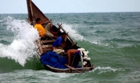 Nelayan tradisional tengah berjuang melawan gelombang laut.