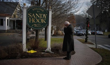 New Jersey resident Steve Wruble, who was moved to drive out to Connecticut to support local residents, grieves for victims of an elementary school mass shooting at the entrance to Sandy Hook village in Newtown, Connecticut December 15.  