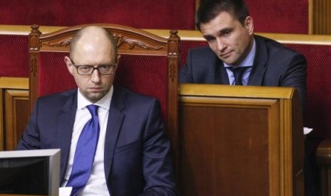 Newly appointed Foreign Minister Pavlo Klimkin (R) and Prime Minister Arseny Yatseniuk listen to Ukrainian President Petro Poroshenko (not pictured) during a session of parliament in Kiev December 2, 2014. 