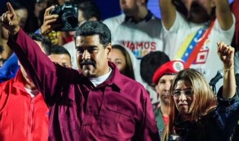 Nicolas Maduro merayakan kemenangannya di Pilpres bersama istrinya, Cilia Flores, Ahad (20/5).