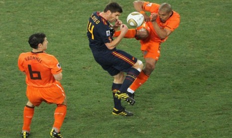 Nigel de Jong (kanan) menendang Xabi Alonso.