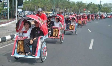 Sejumlah pasangan pengantin diarak menggunakan becak setelah mengikuti nikah massal.