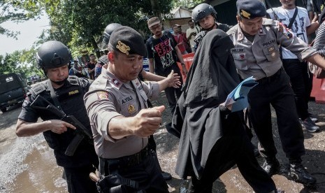 Nila, kakak ipar dari Michael Titus terpidana mati asal Nigeria, dikawal petugas saat akan menuju dermaga penyeberangan Wijayapura, Cilacap, Jateng, Kamis (28/7).