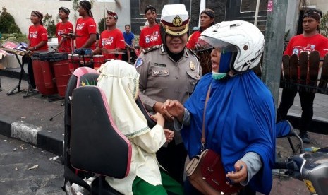 Ning (berkerudung biru) bersama anaknya, Asyifa, ketika berpamitan kepada petugas Direktorat Lalu Lintas Polda DI Yogkarta, Senin (25/9) hari ini. Ditlantas Polda DIY membagikan 1.000 helm bagi pengendara kendaraan bermotor yang membawa anak-anak. 