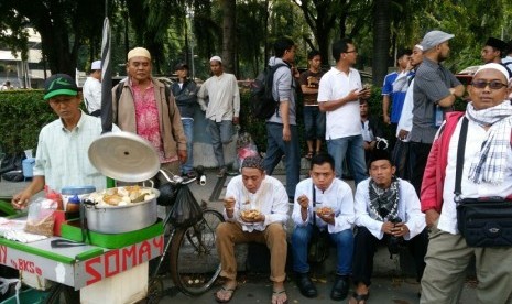 Nirman, seorang tukang soimay meraup untung ketika berdagang di tengah-tengah pengunjuk rasa, Jumat (4/11).