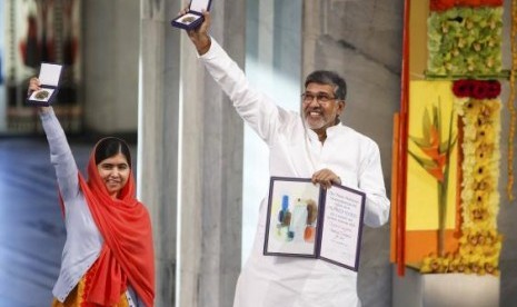 Nobel Peace Prize laureates Malala Yousafzai and Kailash Satyarthi (R) pose with their medals during the Nobel Peace Prize awards ceremony at the City Hall in Oslo December 10, 2014.