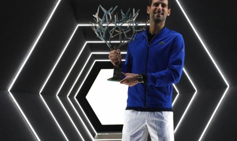 Novak Djokovic memegang trofi juara Paris Masters 2019.