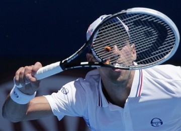 Novak Djokovic, petenis asal Serbia, melepaskan pukulan forehand saat menghadapi petenis Italia, Paolo Lorenzi, di putaran pertama turnamen Australia Terbuka di Melbourne, Australia, Selasa (17/1). 