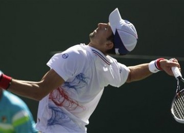 Novak Djokovic, petenis Serbia, melepaskan service keras ke arah petenis Spanyol, Pablo Andujar, di pertandingan turnamen BNP Paribas Open di Indian Wells, California, Rabu (14/3). 