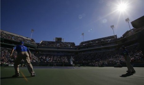 Novak Djokovic (tengah), petenis Serbia, mengembalikan servis petenis Bulgaria, Grigor Dimitrov, di turnamen BNP Paribas Terbuka di Indian Wells, California, Selasa (12/3). 