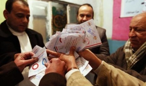 Officials count ballots after polls closed in Cairo, January 15, 2014.