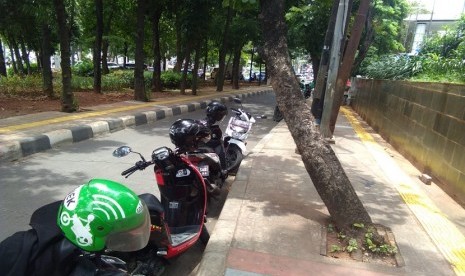 Ojek online memarkir kendaraan di tepi jalan di depan Pejaten Village