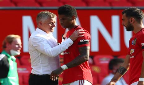 Ole Gunnar Solskjaer berbincang dengan Marcus Rashford.